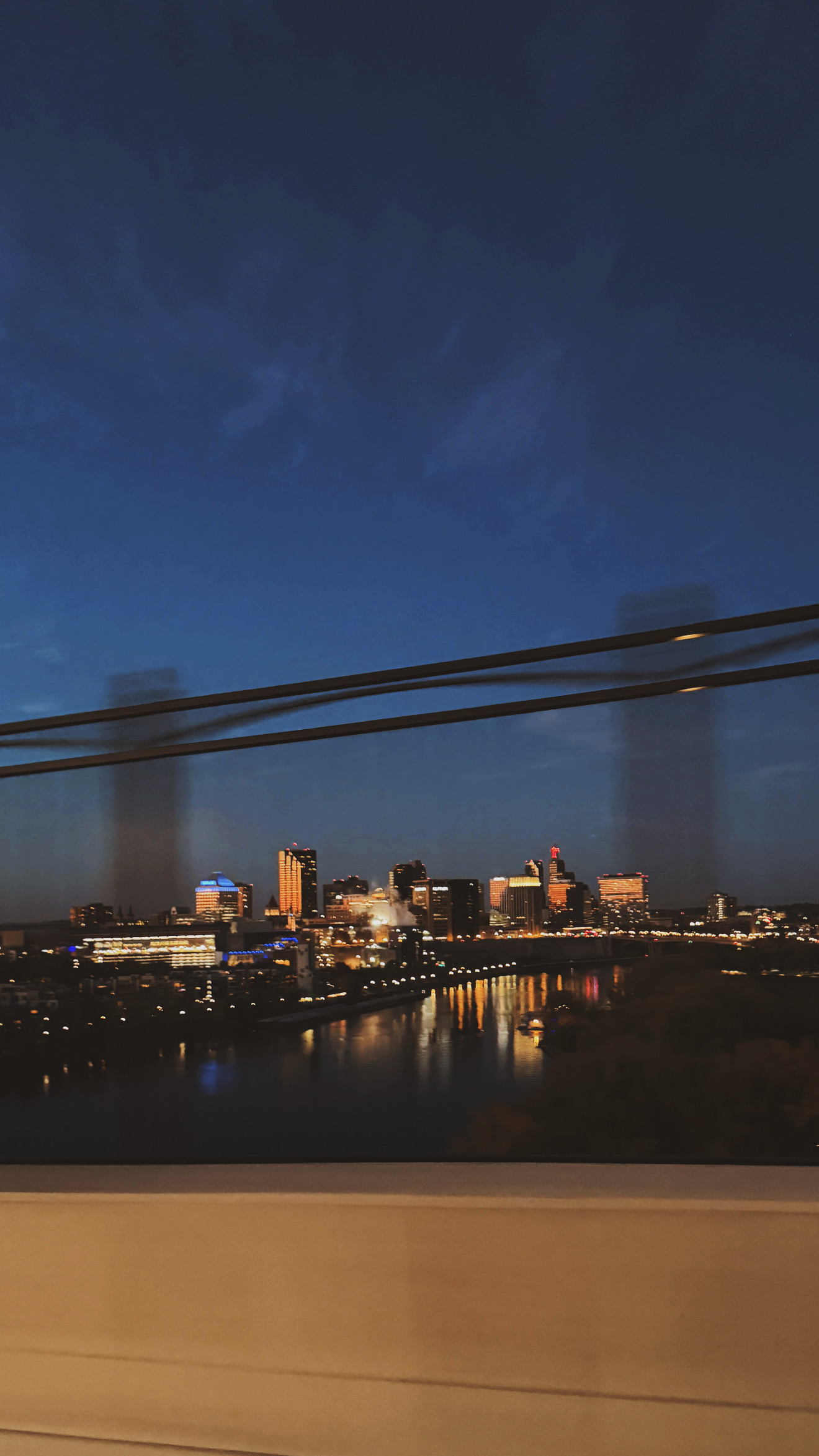 st. paul at dusk behind the shore of the mississippi river taken while crossing a bridge in a car